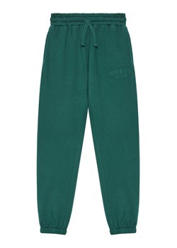 Guess Spodnie dresowe L5YQ19 KAV34 Zielony Regular Fit ze sklepu MODIVO w kategorii Spodnie chłopięce - zdjęcie 184575359