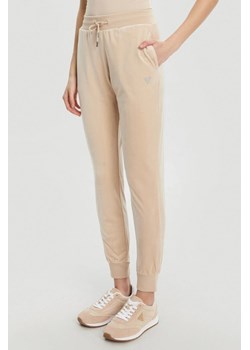 GUESS Beżowe damskie spodnie dresowe Couture, Rozmiar XS ze sklepu outfit.pl w kategorii Spodnie damskie - zdjęcie 184734249