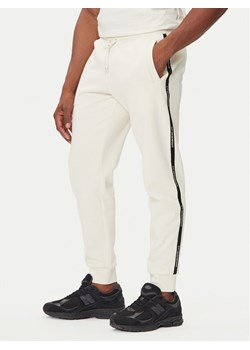 EA7 Emporio Armani Spodnie dresowe 7M000974 AF10377 U1105 Beżowy Regular Fit ze sklepu MODIVO w kategorii Spodnie męskie - zdjęcie 184810906