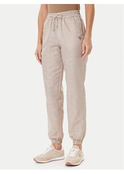 Guess Spodnie dresowe V5YB14 WHFU0 Beżowy Regular Fit ze sklepu MODIVO w kategorii Spodnie damskie - zdjęcie 184848896