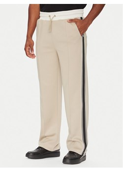 Guess Spodnie dresowe Z5YB14 KCRU2 Beżowy Regular Fit ze sklepu MODIVO w kategorii Spodnie męskie - zdjęcie 184857997