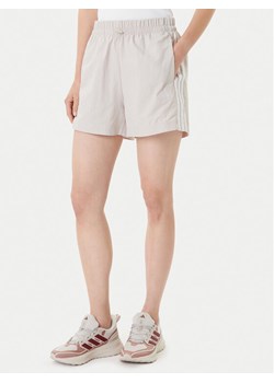 adidas Szorty sportowe Essentials 3-Stripes JC8165 Beżowy Loose Fit ze sklepu MODIVO w kategorii Szorty - zdjęcie 184906138
