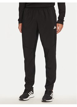 adidas Spodnie dresowe Own The Run IK5024 Czarny Regular Fit ze sklepu MODIVO w kategorii Spodnie męskie - zdjęcie 185030907