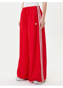 adidas Spodnie dresowe adicolor Firebird JD3388 Czerwony Loose Fit ze sklepu MODIVO w kategorii Spodnie damskie - zdjęcie 185039109
