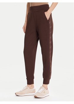 Guess Spodnie dresowe W5YB11 KBYE2 Brązowy Regular Fit ze sklepu MODIVO w kategorii Spodnie damskie - zdjęcie 186387588