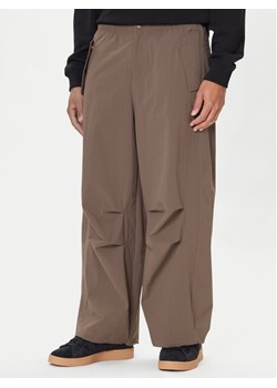 adidas Spodnie materiałowe Premium Essentials Utility Parachute JW1087 Brązowy Loose Fit ze sklepu MODIVO w kategorii Spodnie męskie - zdjęcie 186636717