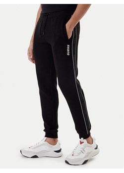 Guess Spodnie dresowe Mickey Z2YB09 KB3P2 Czarny Regular Fit ze sklepu MODIVO w kategorii Spodnie męskie - zdjęcie 187516476