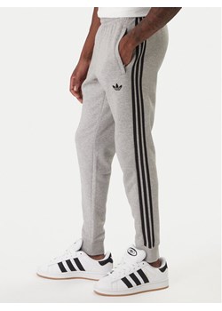 adidas Spodnie dresowe 3-Stripes KE2428 Szary Slim Fit ze sklepu MODIVO w kategorii Spodnie męskie - zdjęcie 187851706