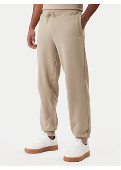 Guess Spodnie dresowe Z6RB12 KAIJ1 Beżowy Regular Fit ze sklepu MODIVO w kategorii Spodnie męskie - zdjęcie 188005647