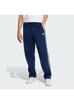 adidas Spodnie dresowe Firebird KD8316 Granatowy Loose Fit ze sklepu MODIVO w kategorii Spodnie męskie - zdjęcie 188013408