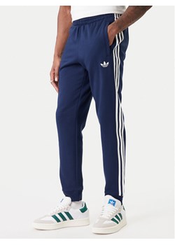 adidas Spodnie dresowe 3-Stripes KE3561 Granatowy Slim Fit ze sklepu MODIVO w kategorii Spodnie męskie - zdjęcie 188062115