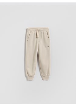 Reserved - Bawełniane spodnie jogger - beżowy ze sklepu Reserved w kategorii Spodnie chłopięce - zdjęcie 188066639