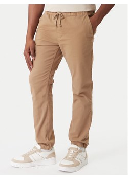 Tommy Jeans Joggery DM0DM23102 Brązowy Regular Fit ze sklepu MODIVO w kategorii Spodnie męskie - zdjęcie 188074838