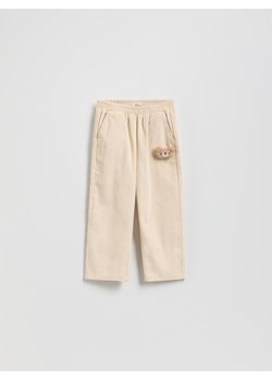 Reserved - Sztruksowe spodnie z aplikacją - kremowy ze sklepu Reserved w kategorii Spodnie dziewczęce - zdjęcie 188090785