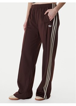 adidas Spodnie dresowe Firebird KG3706 Brązowy Loose Fit ze sklepu MODIVO w kategorii Spodnie damskie - zdjęcie 188118446