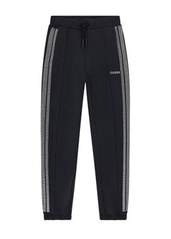 Guess Spodnie dresowe J6RB17 KCAY2 Czarny Regular Fit ze sklepu MODIVO w kategorii Spodnie chłopięce - zdjęcie 188401515