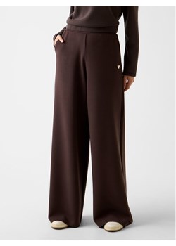 Guess Spodnie dresowe V4YB07 KCAY2 Brązowy Relaxed Fit ze sklepu MODIVO w kategorii Spodnie damskie - zdjęcie 188403626