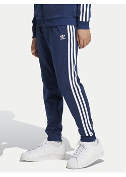 adidas Spodnie dresowe adicolor SST IY7466 Granatowy Regular Fit ze sklepu MODIVO w kategorii Spodnie chłopięce - zdjęcie 188418869