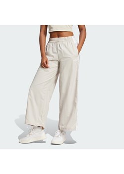 adidas Spodnie dresowe Essentials 3-Stripes JC8168 Beżowy Loose Fit ze sklepu MODIVO w kategorii Spodnie damskie - zdjęcie 188469869