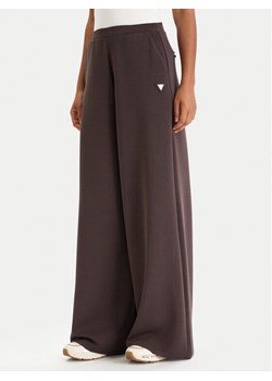 Guess Spodnie dresowe V4YB07 KCAY2 Brązowy Relaxed Fit ze sklepu MODIVO w kategorii Spodnie damskie - zdjęcie 188506246