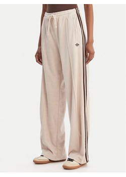 adidas Spodnie dresowe Terry Towel Firebird KQ6661 Beżowy Loose Fit ze sklepu MODIVO w kategorii Spodnie damskie - zdjęcie 188514008