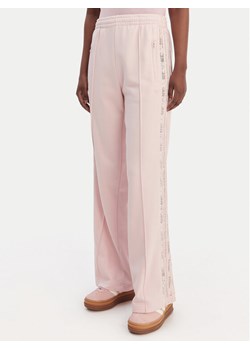 adidas Spodnie dresowe Firebird Lace KC6444 Różowy Loose Fit ze sklepu MODIVO w kategorii Spodnie damskie - zdjęcie 188869188