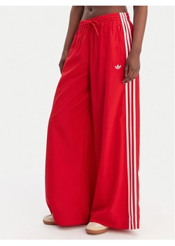 adidas Spodnie dresowe Firebird Adilenium KD6299 Czerwony Regular Fit ze sklepu MODIVO w kategorii Spodnie damskie - zdjęcie 188869195