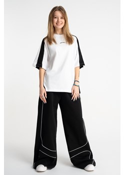 Czarne spodnie dresowe WIDE LEG z kontrastowymi wypustkami podkreślające cięcia, Rozmiar - 140, Kolor - Czarny ze sklepu REPORTER w kategorii Spodnie dziewczęce - zdjęcie 189110776