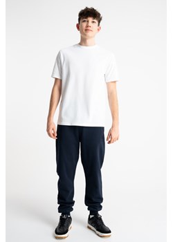 Granatowe spodnie dresowe SLIM z minimalistycznym nadrukiem, Rozmiar - 140, Kolor - Granatowy ze sklepu REPORTER w kategorii Spodnie chłopięce - zdjęcie 189110977