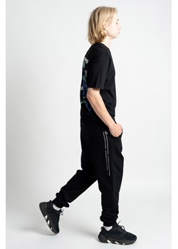 Czarne spodnie dresowe oversize z minimalistycznym nadrukiem na nogawce, Rozmiar - 146, Kolor - Czarny ze sklepu REPORTER w kategorii Spodnie chłopięce - zdjęcie 189316506