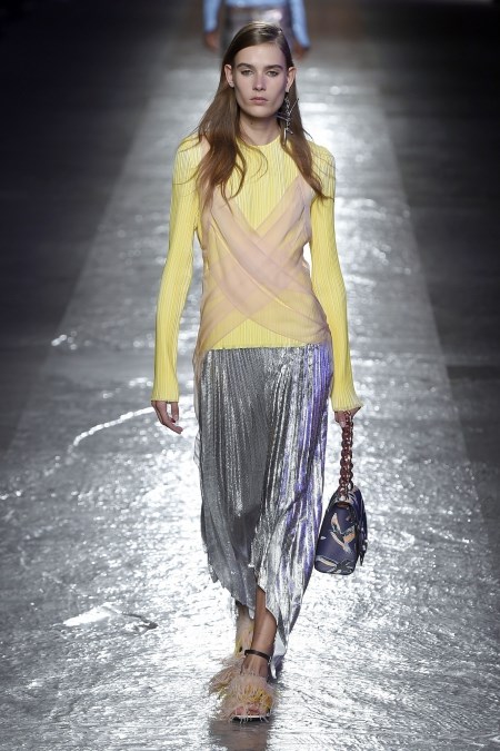 Modelka z pokazu Emilio Pucci w metalicznej, srebrnej spódnicy midi i żółtej bluzce. 